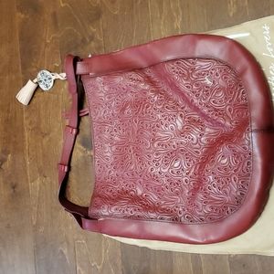 Stunning genuine red lrather engraved Velez handbag.